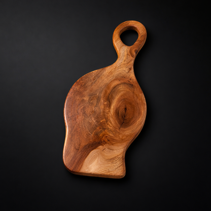 Wooden cutting board with a handle on a black background