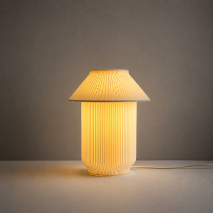 A pleated table lamp with a warm yellow glow, featuring a conical shade and a ribbed cylindrical base, set against a neutral gray background.